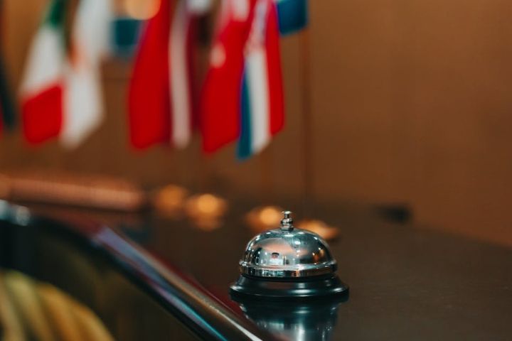 Cloche de réception d’hôtel de luxe avec drapeaux internationaux en arrière-plan.